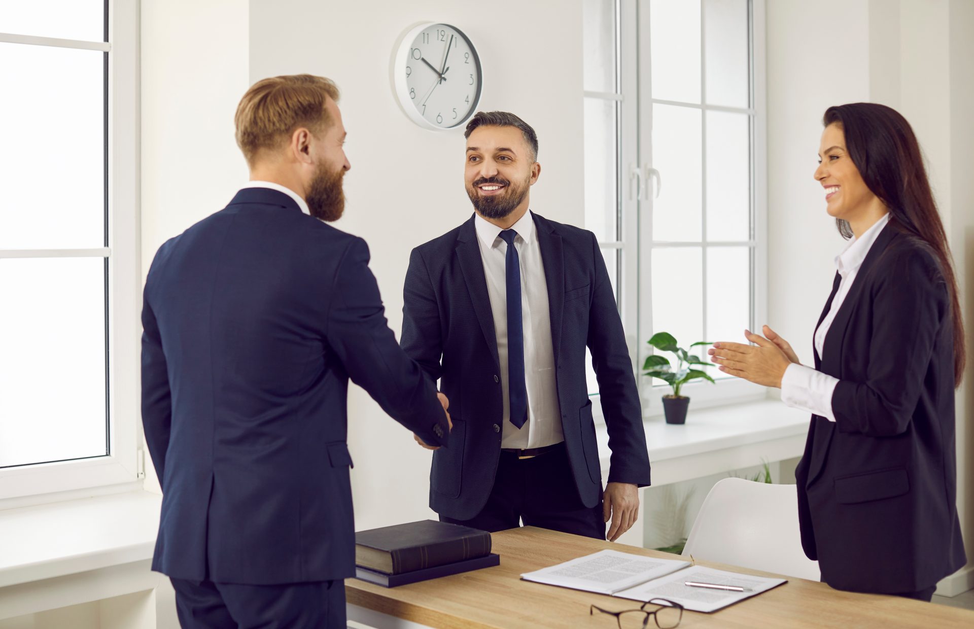 Happy client and lawyer exchanging a handshake in the office or courthouse. Businessman shaking hands with his attorney or business consultant, thanking him for his service and professional law advice