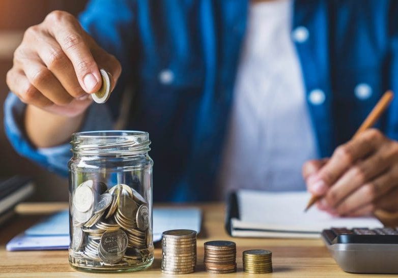 housewife puts a coin in a jar to save money for the future. aft housewife puts a coin in a jar to save money for the future. after retirement and record keeping of income, expenditure, savings and financial concepts.
