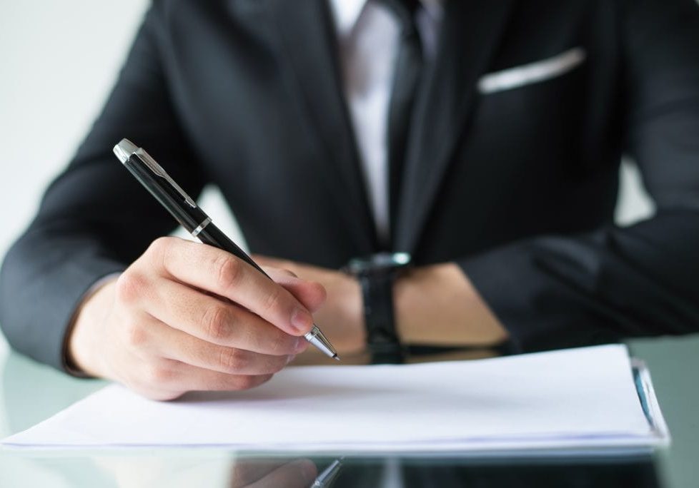 Company owner signing contract. Closeup of businessman writing in documents. Business meeting concept